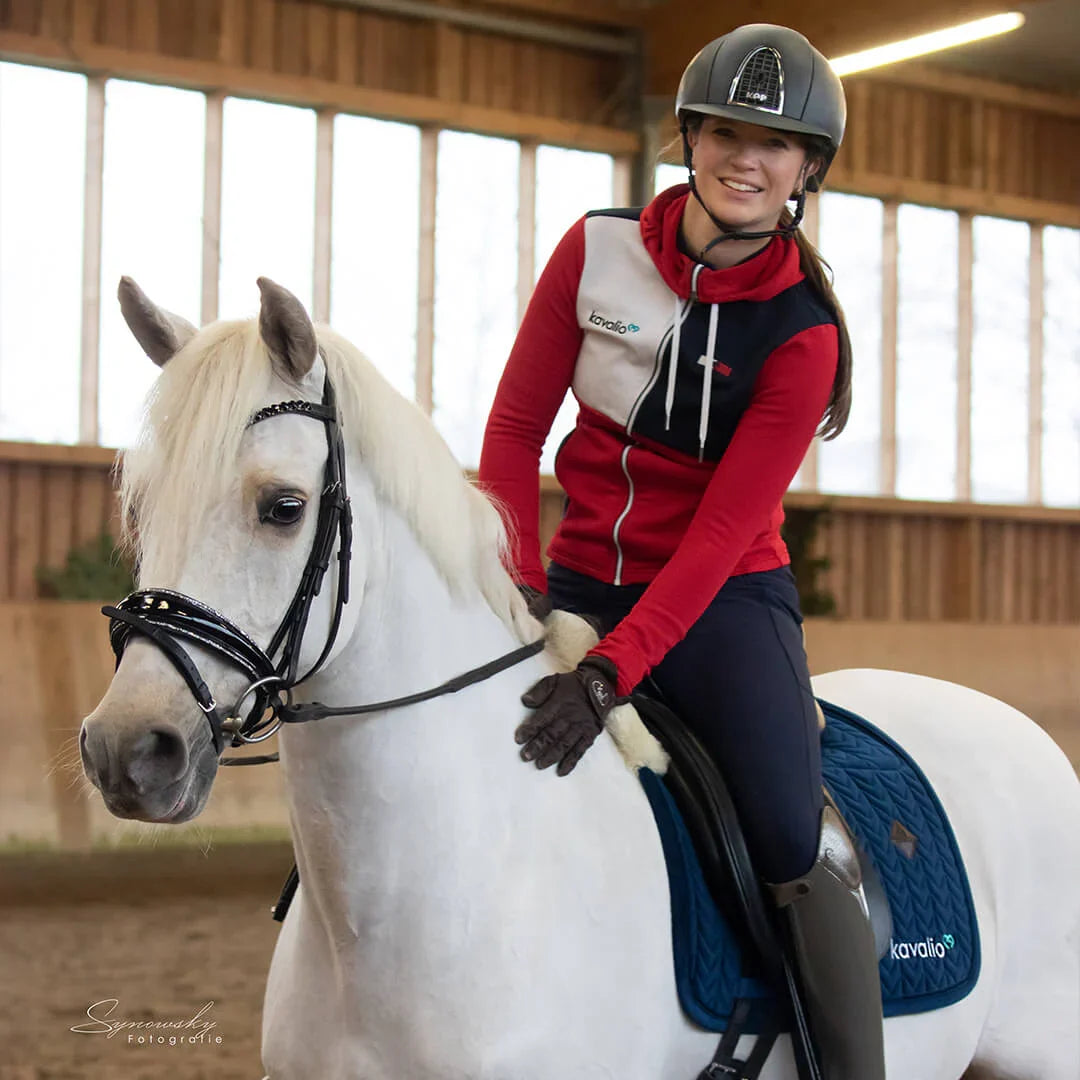 Reiterin auf weißem Pferd in der Halle mit blauer Schabracke, Die Kentucky Velvet Skin Friendly Schabracke im Test mit Caro von Team.GB.