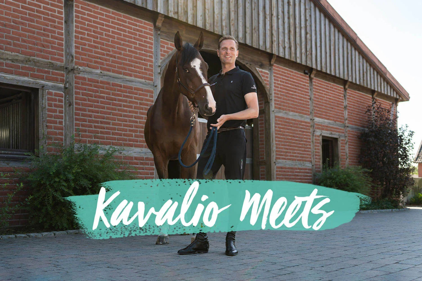 Mann steht mit braunem Pferd vor einem Stallgebäude, KAVALIO MEETS Jens Baackmann – Meet and Greet mit unserem Teamreiter.