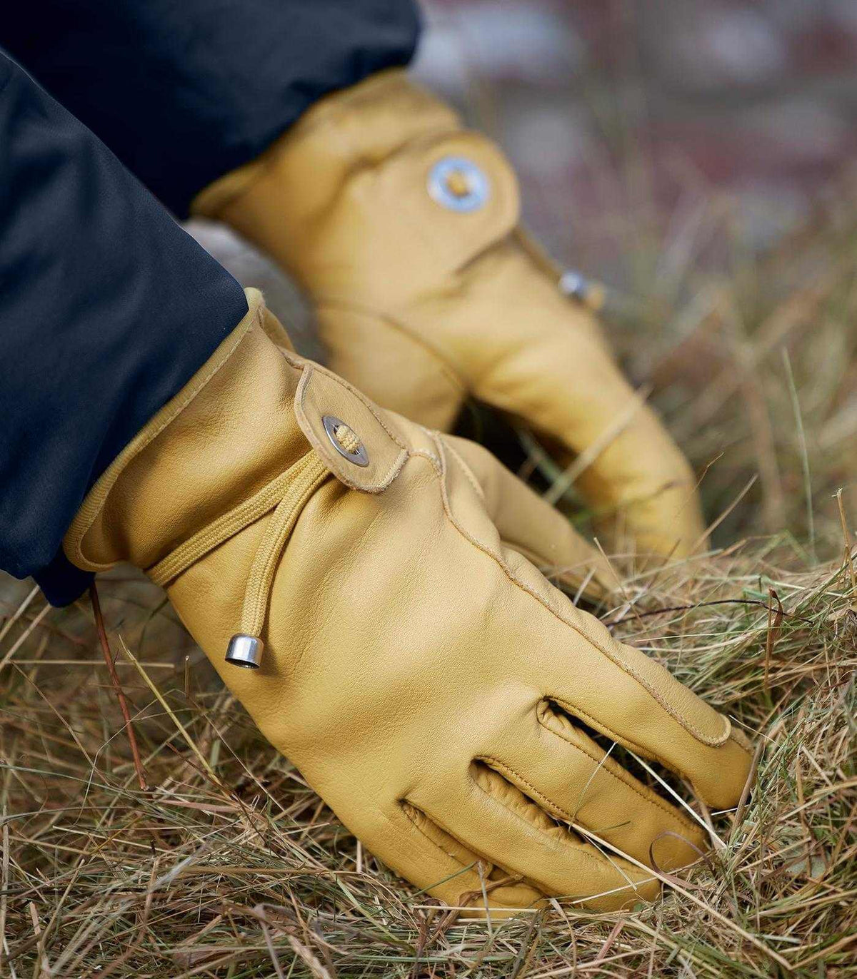 Arbeitshandschuh Texas, Beige, Detailaufnahme beim Arbeiten im Gras.