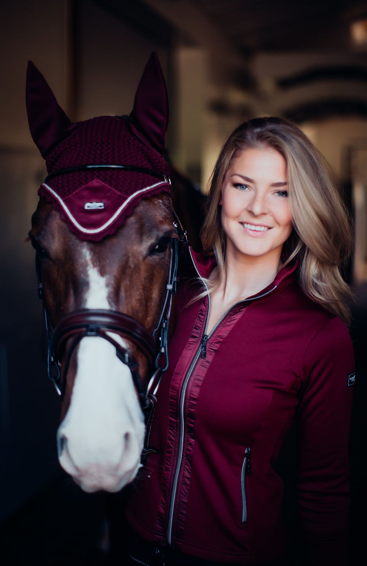 Equestrian Stockholm Fliegenmütze Bordeaux, Pferd und Reiterin im Stall.