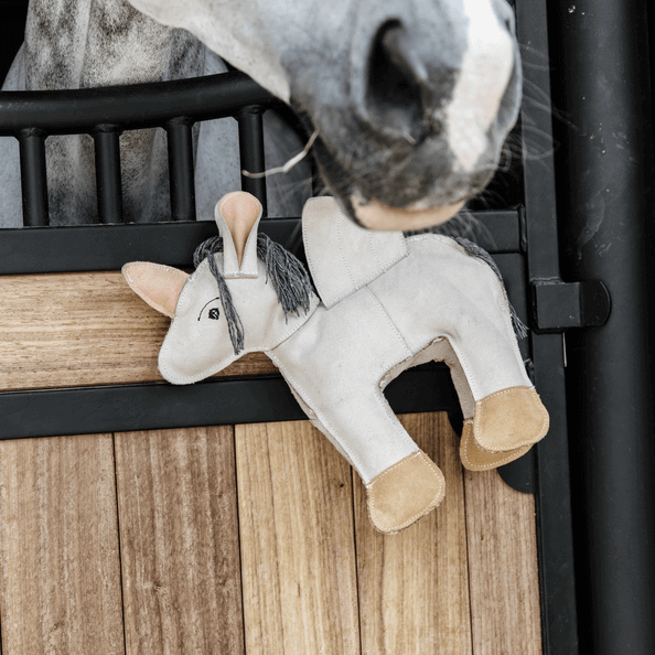 Pferdespielzeug Relax Horse Toy Fantasie, Produkt allein, weiße Pferdeplüschfigur am Stallgitter.