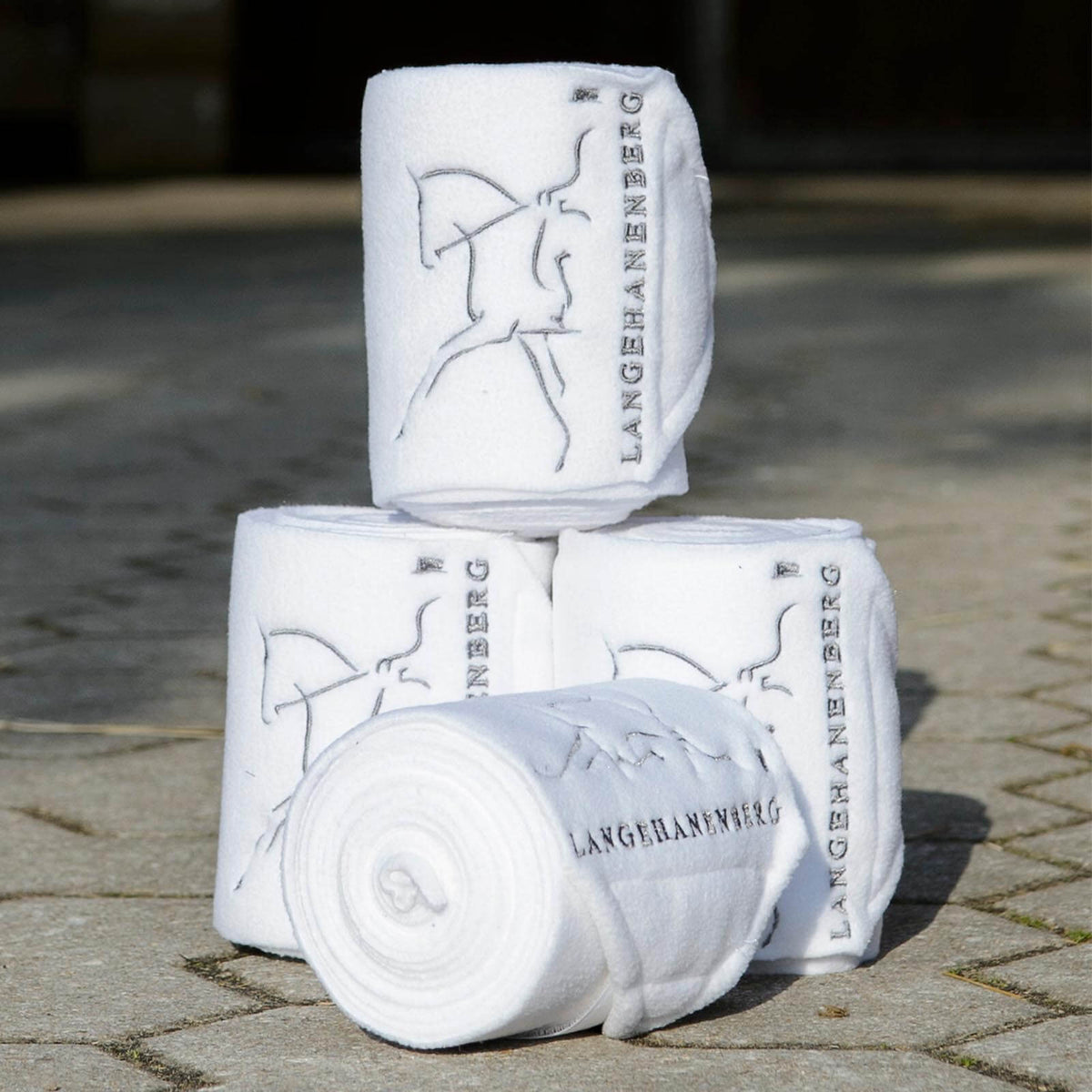 Langehanenberg Bandagen mit Logo Fleecebandagen Silber/Weiß, mehrere Bandagenrollen auf Pflaster.