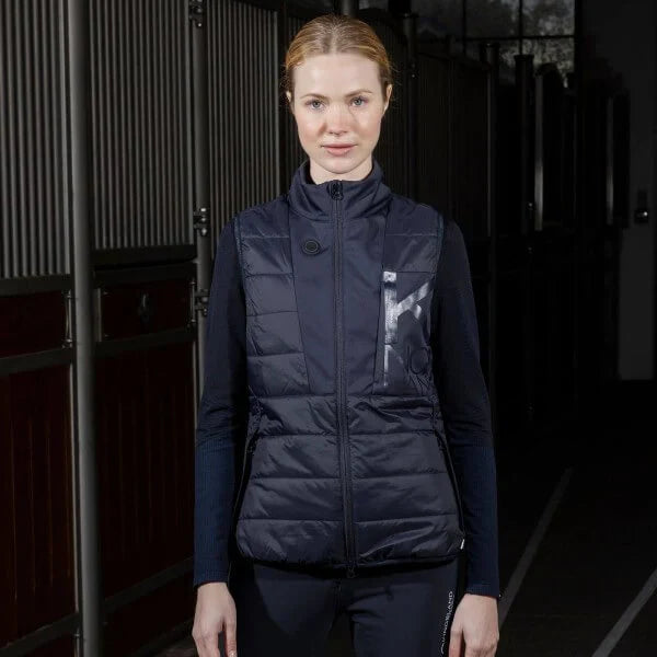 Frau trägt navyfarbene Steppweste, COZY & CHIC – mit dieser beheizbaren Kleidung überstehst du die Wintermonate.