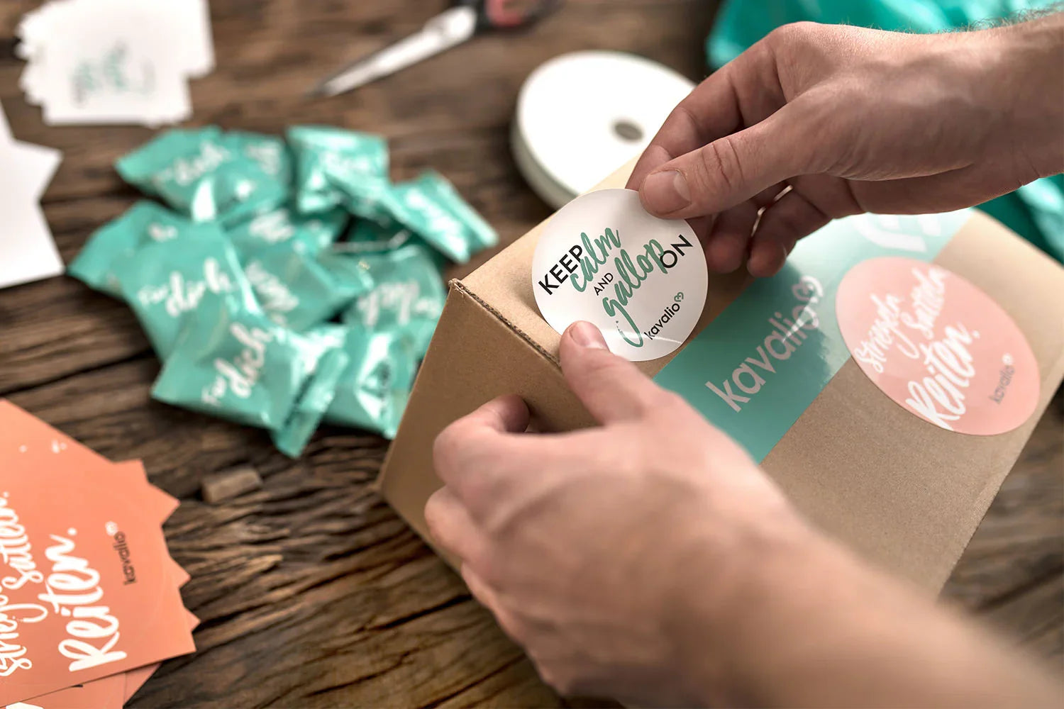 Hände kleben einen Aufkleber auf ein Paket, Noch mehr Vorteile für dich - Kostenfreier Rückversand.