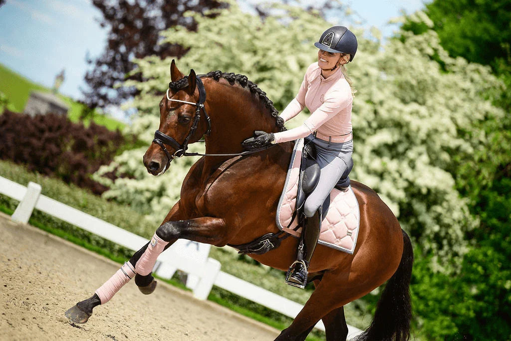 Reiterin trainiert ein Dressurpferd auf dem Reitplatz, Ab ins Viereck – die hohe Kunst des Dressurreitens im Überblick.