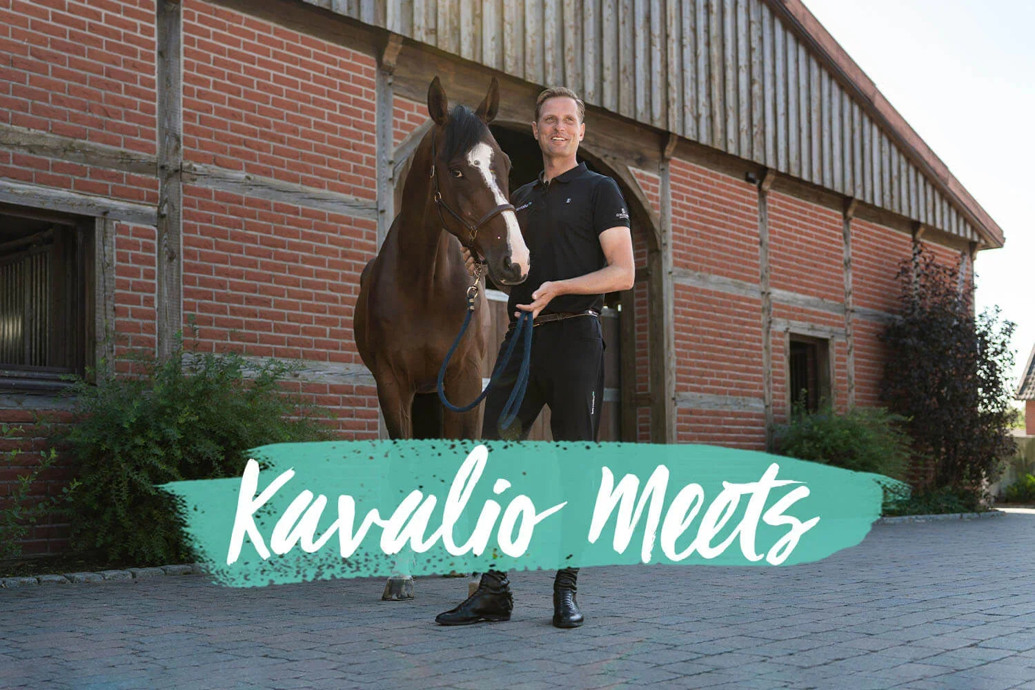 Mann steht mit braunem Pferd vor einem Stallgebäude, KAVALIO MEETS Jens Baackmann – Meet and Greet mit unserem Teamreiter.