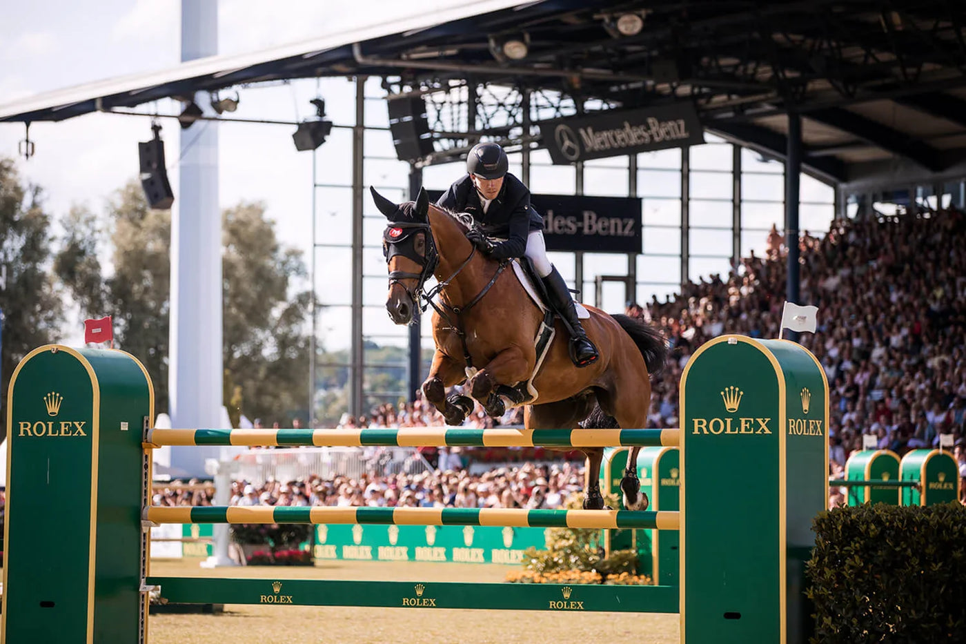 Reiter springt mit Pferd über Rolex-Hindernis im Stadion, Best time of the year: Das legendäre CHIO Aachen 2023 steht vor der Tür – ein Reiterspektakel der Extraklasse.