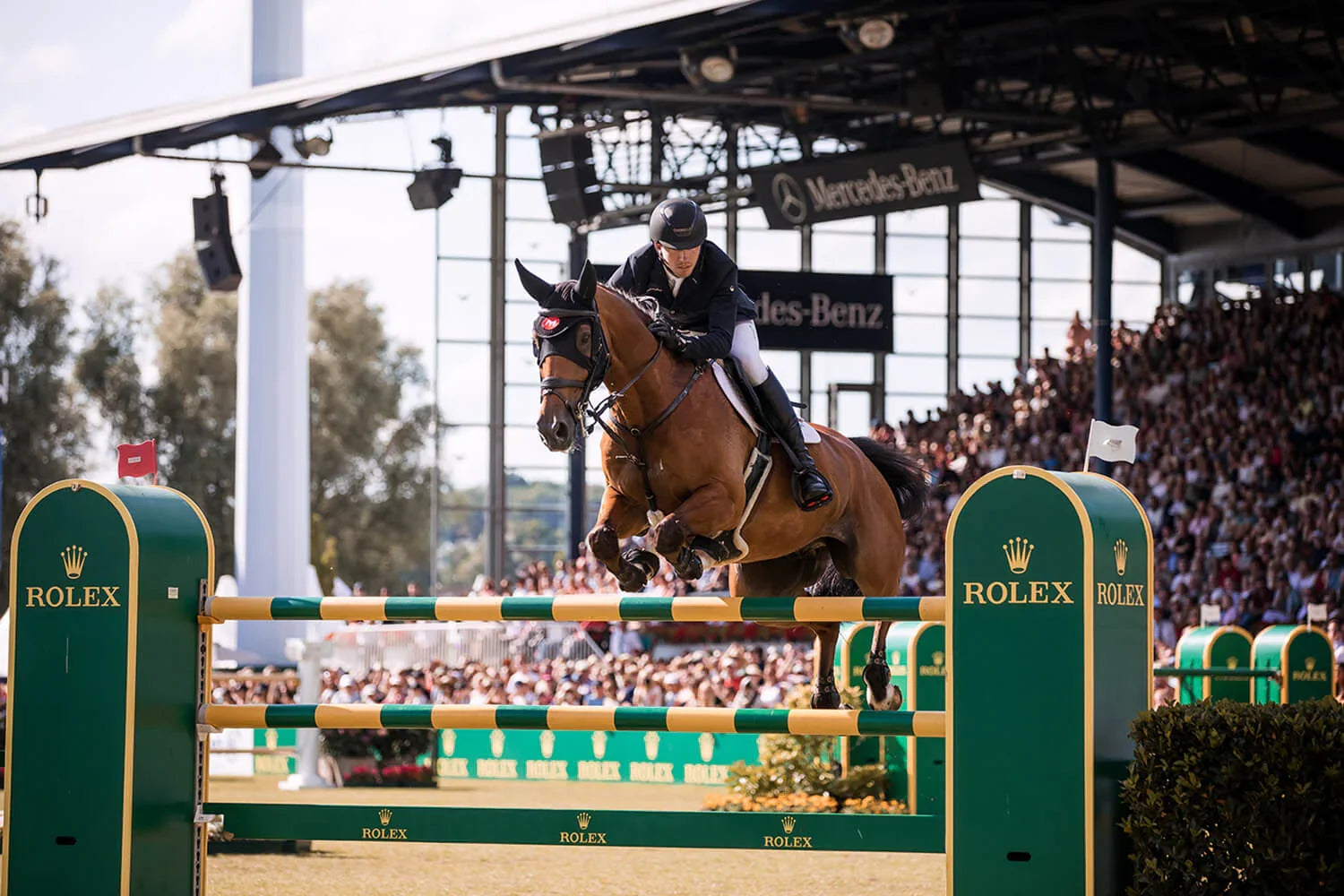 Reiter springt mit Pferd über Rolex-Hindernis im Stadion, Best time of the year: Das legendäre CHIO Aachen 2023 steht vor der Tür – ein Reiterspektakel der Extraklasse.