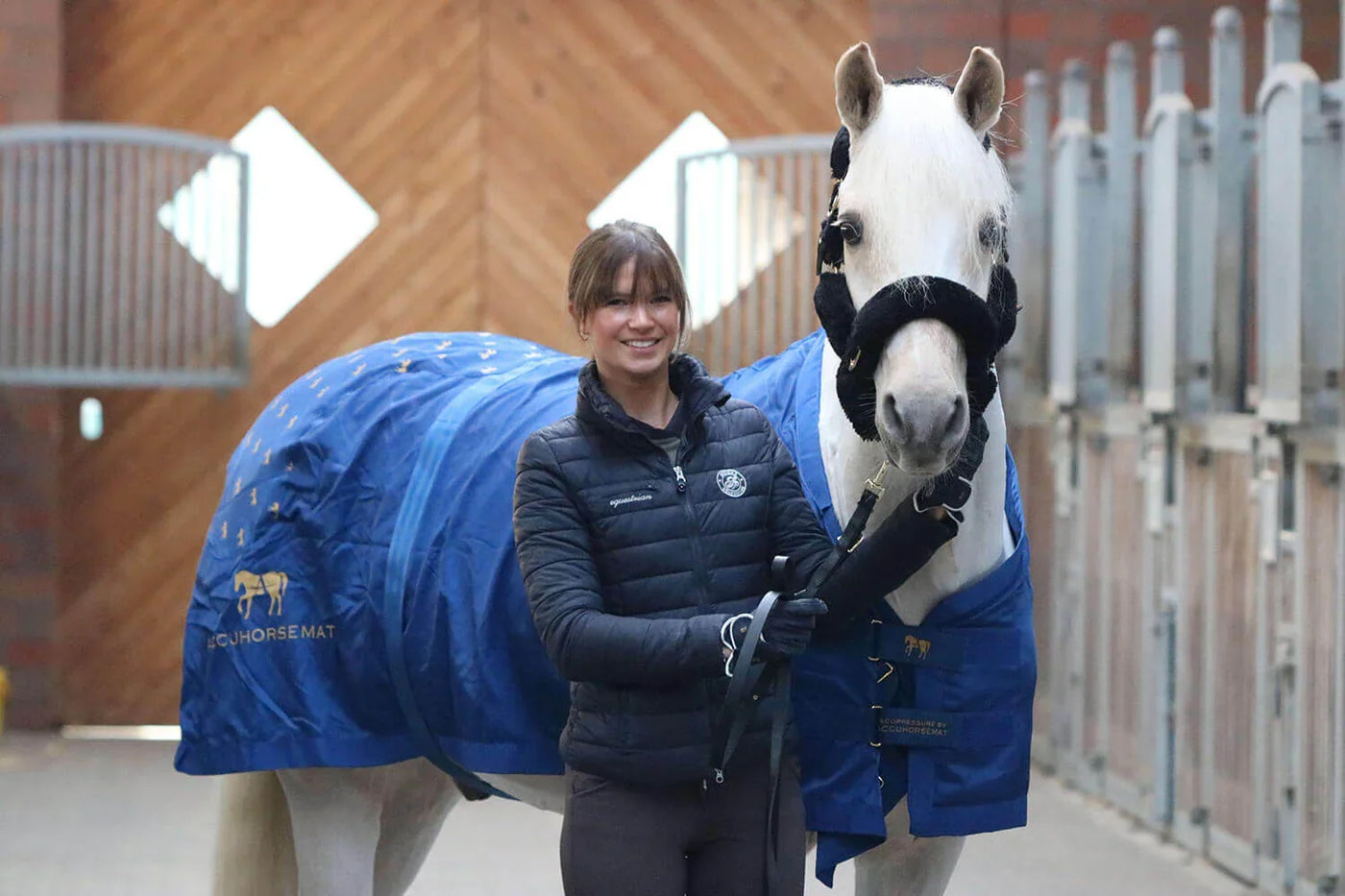 Reiterin hält ein weißes Pferd mit blauer Accuhorsemat-Decke, Accuhorsemat | Team GB testet für dich.