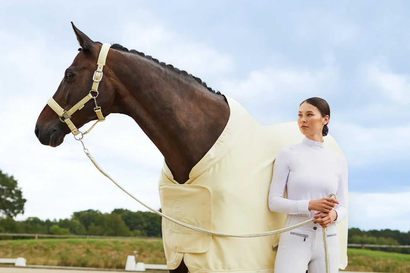 Pferd mit heller Abschwitzdecke und Reiterin im Gelände, Pure Glücksgefühle mit der neuen Platinum Pure 2023 Kollektion von Eskadron.