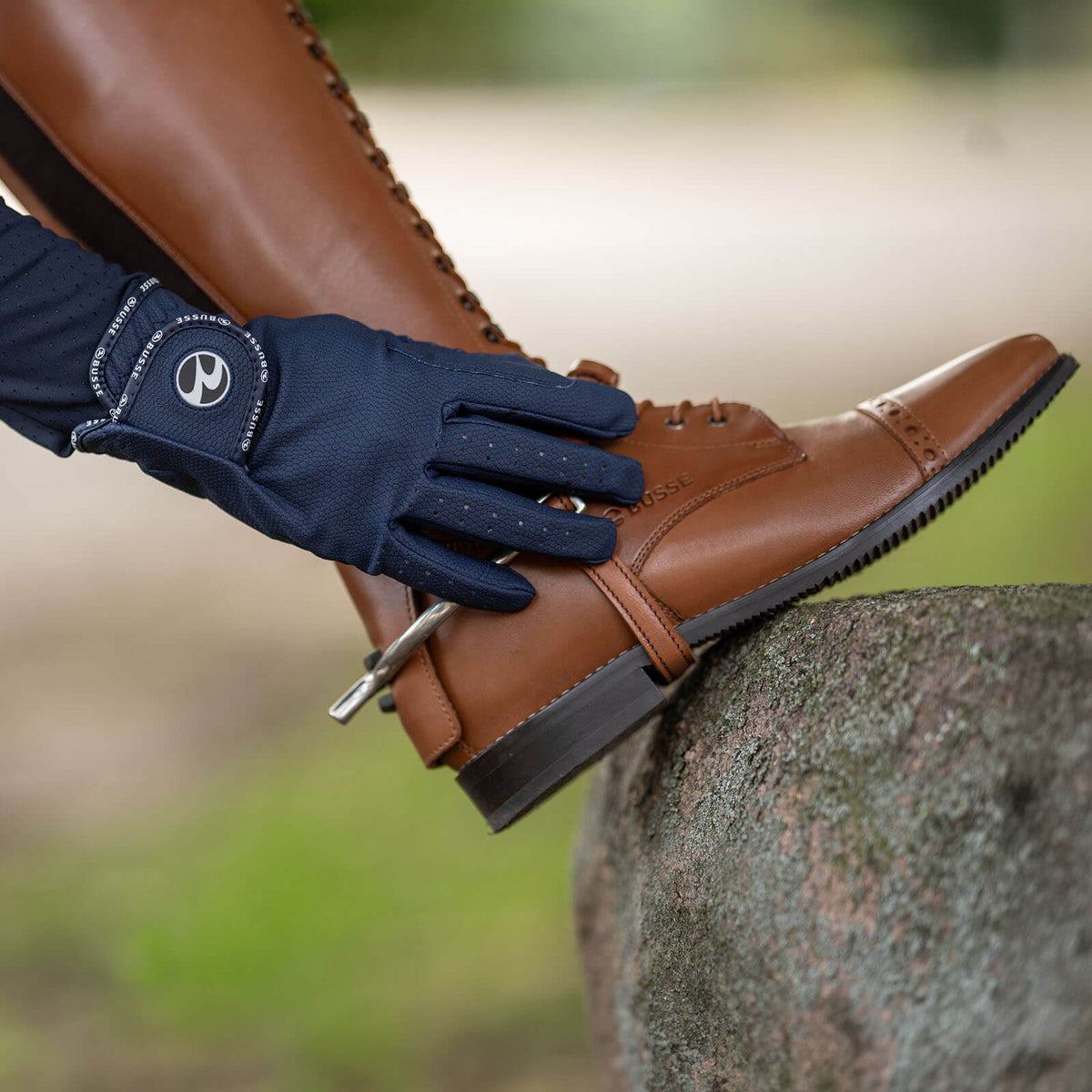 Reithandschuhe Unisex Casual GP Ganzjahreshandschuh, Navy, am Reiter mit braunem Stiefel.