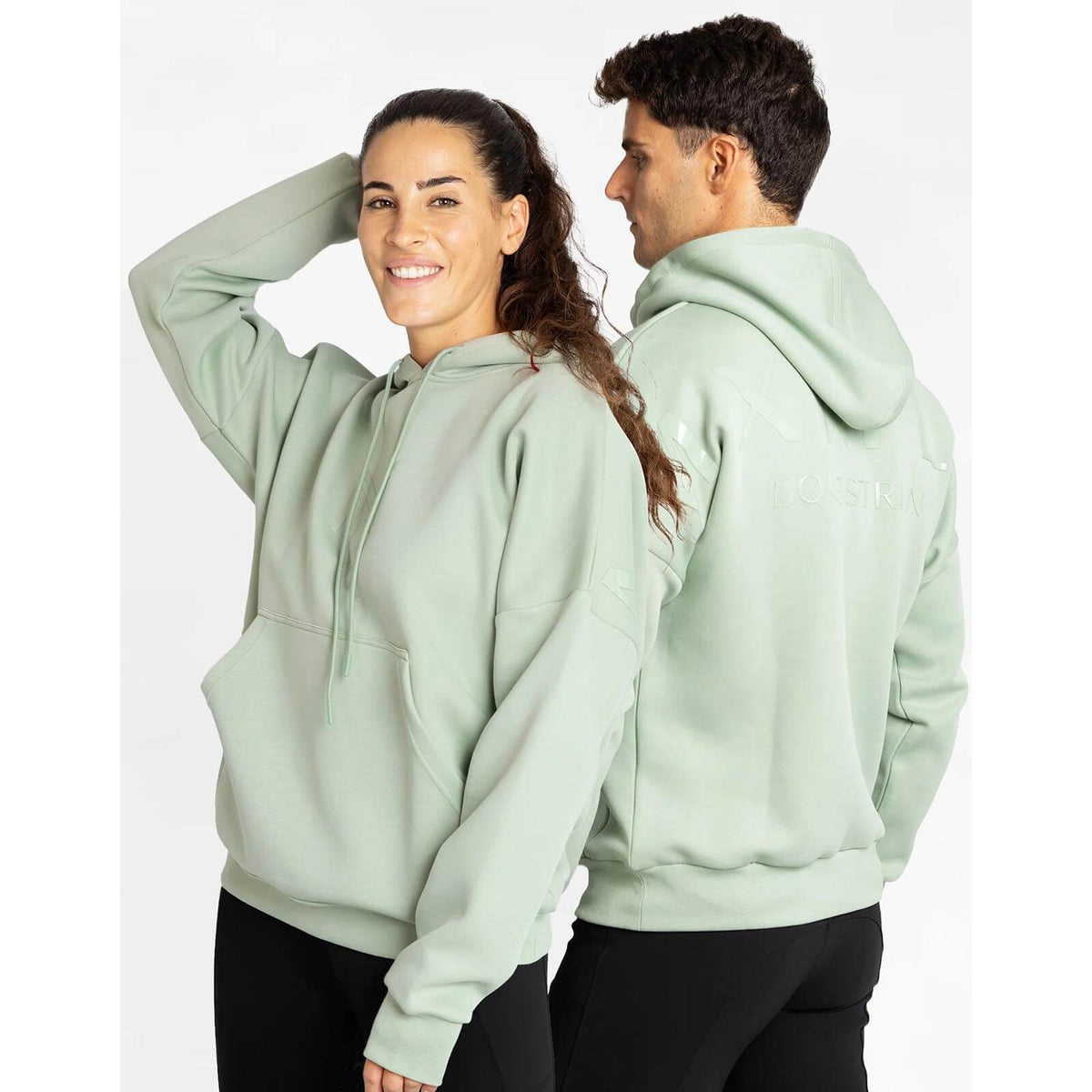Hoodie Unisex Icon Oversized Kapuzenpullover, Sage Green, zwei Personen tragen das Modell.