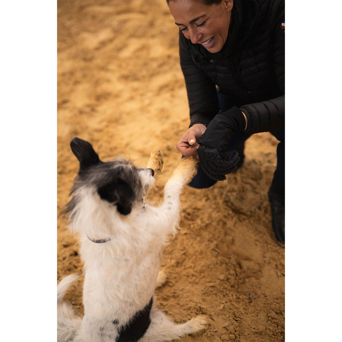 Roeckl Winterreithandschuh Unisex Dog-Walker Neuberg Winter Stallhandschuh, Schwarz, Person füttert Hund im Stall.