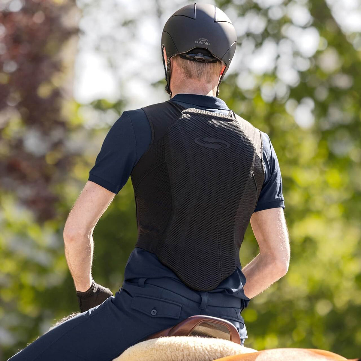 Swing Reithelm Unisex H24 Chrome, Schwarz, Person beim Reiten von hinten.