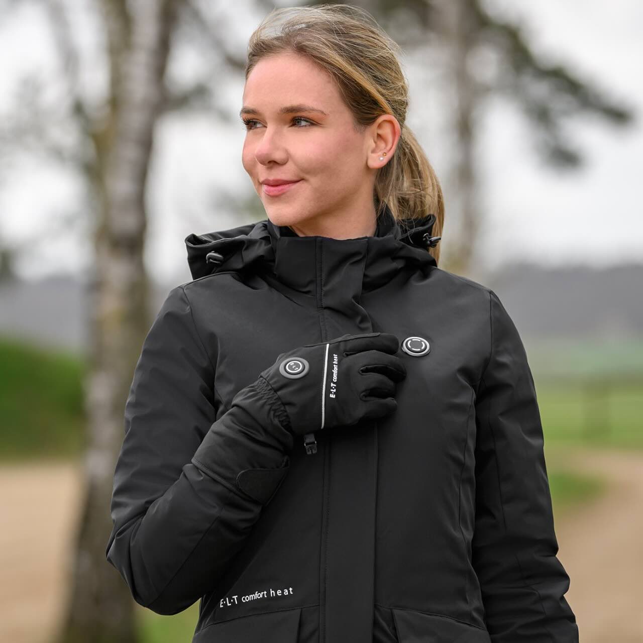 E.L.T Heizparka Damen Comfort Heat Heizjacke, Schwarz, Person trägt das Produkt im Freien.