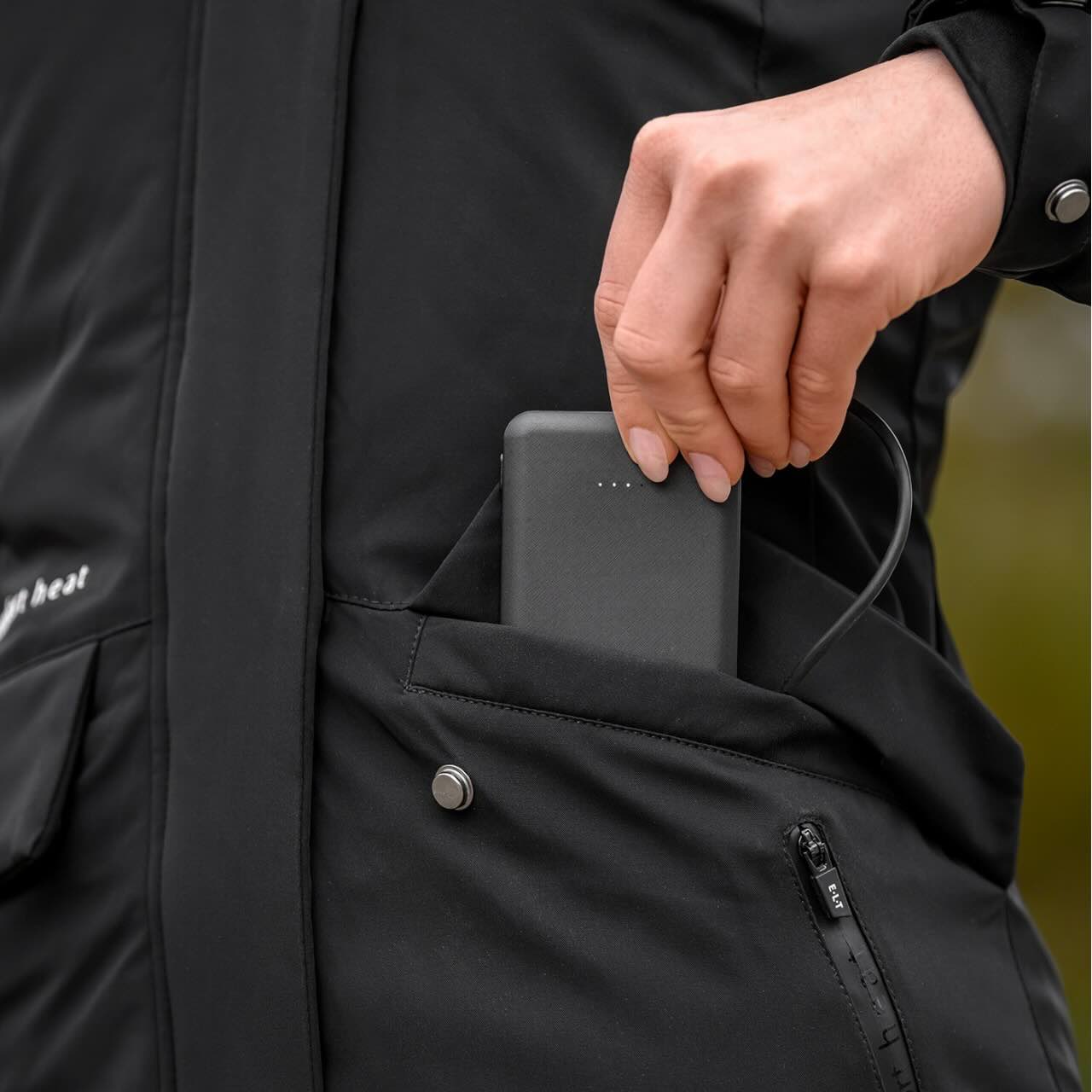 E.L.T Heizparka Damen Comfort Heat Heizjacke, Schwarz, Detailaufnahme mit Powerbank in der Tasche.