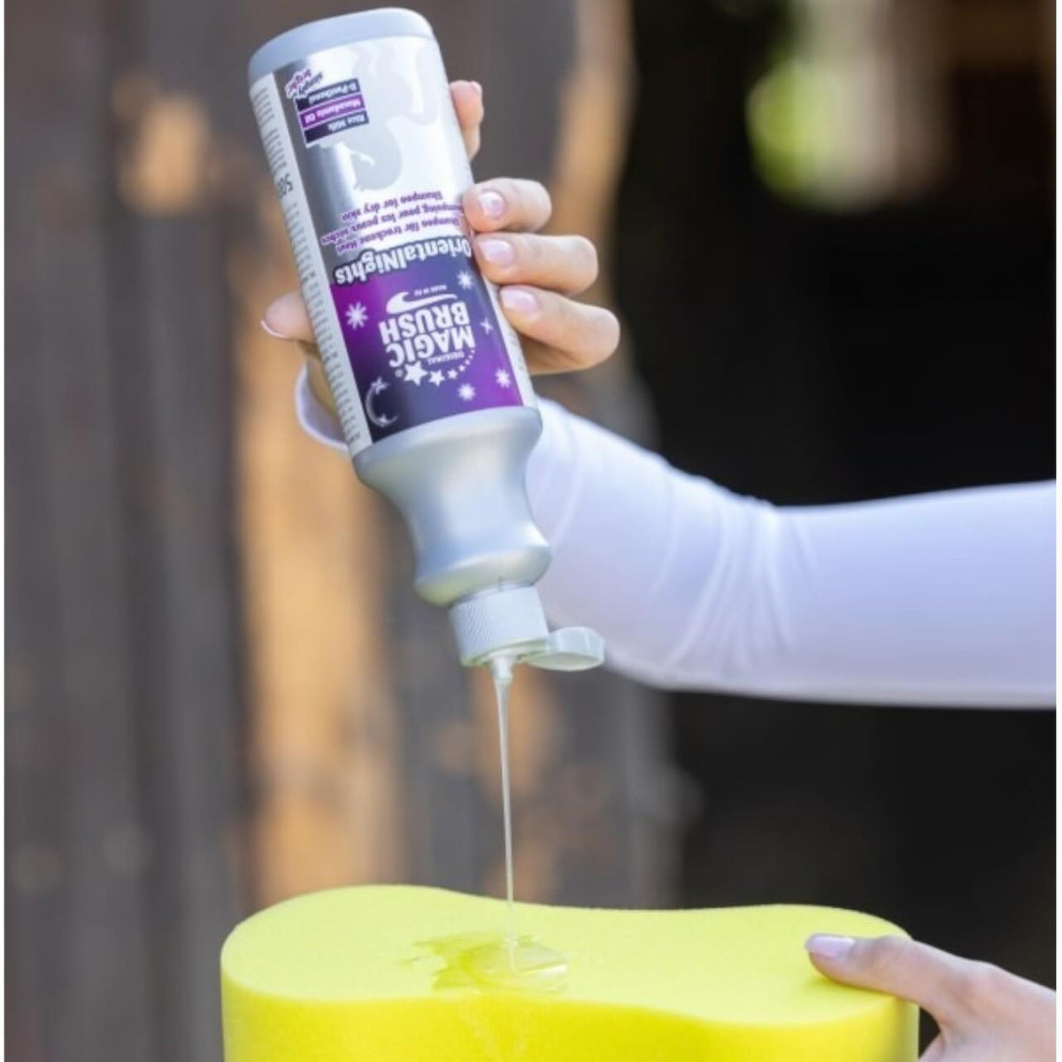 Magic Brush Shampoo Pferdeshampoo, mehrere Farbvarianten, Anwendung auf gelbem Schwamm.