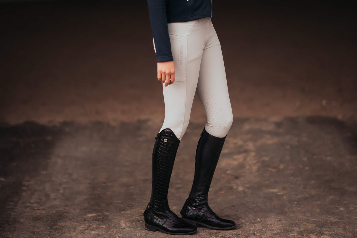 Reithose Jump Elite, Hellbeige, an Person im Stall getragen.