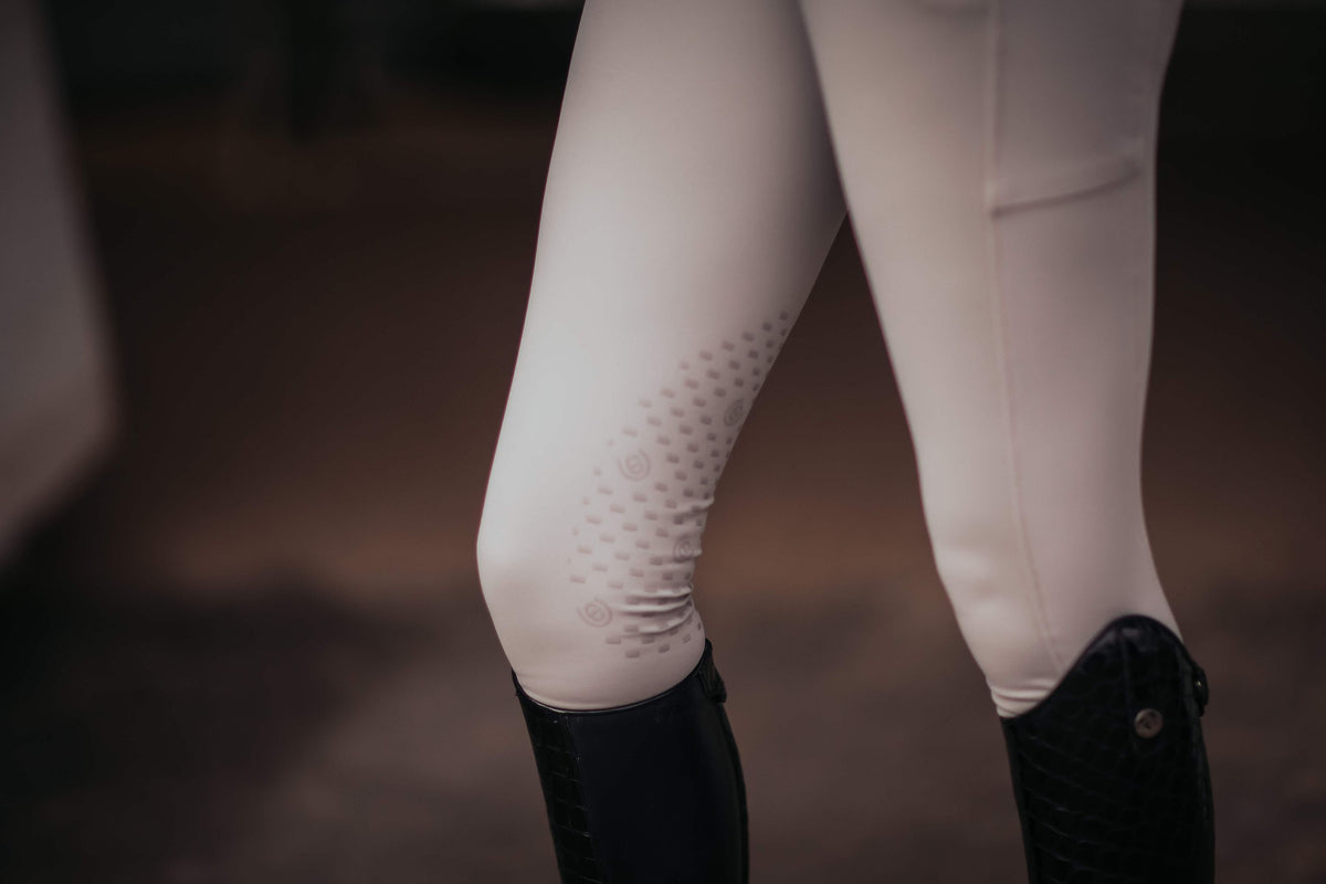 Reithose Jump Elite, Weiß, Detailaufnahme am Reiter mit Reitstiefeln.