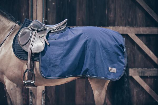 Ausreitdecke 160g Quarter Rug All Weather, Navy, am Pferd unter dem Sattel in der Stallgasse.