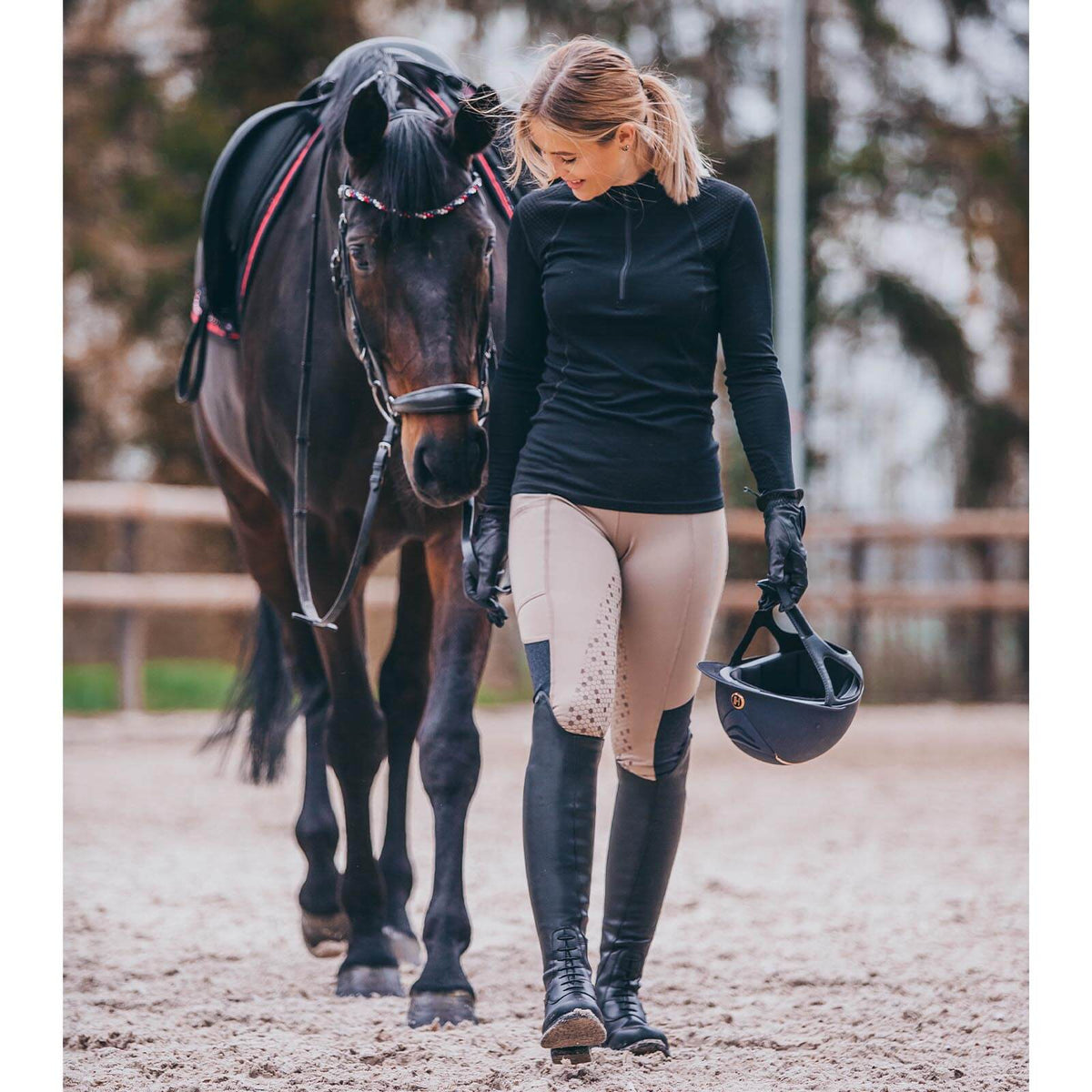 Suedwind Equestrian Reitstiefel Nova Tall Vegan, Schwarz, Reiterin mit Pferd auf dem Reitplatz.